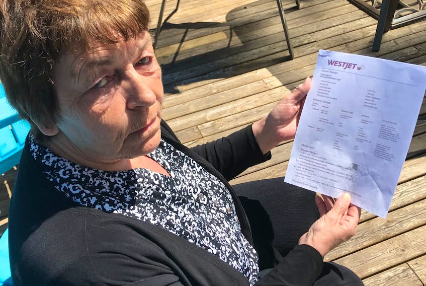 Debbie Braun looks over flight information for her flight to Calgary. The Amherst woman was supposed to fly out of Moncton on Sunday but was turned back at the New Brunswick border, forcing her to book another flight out of Halifax at additional cost.
