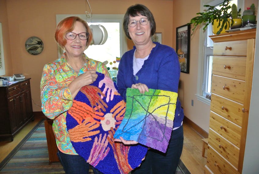 Carol McCall (left) and Gwen Dixon look over some of the items being featured at an exhibit at the Tidnish Bridge Art Gallery that runs through Oct. 13. The exhibit is a quirky take on both of their experiences with breast cancer.