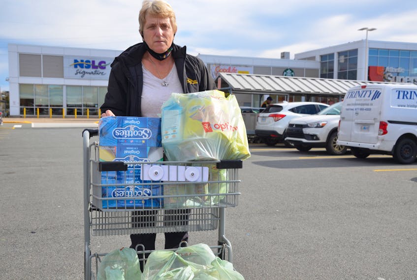 Bridgid Bowers wheels her grocery cart laden with plastic grocery bags across the parking lot of the Atlantic Superstore on Joseph Howe Drive in Halifax on Wednesday, Oct. 28. Bowers says the single-use plastic bag ban will not have much impact on her.