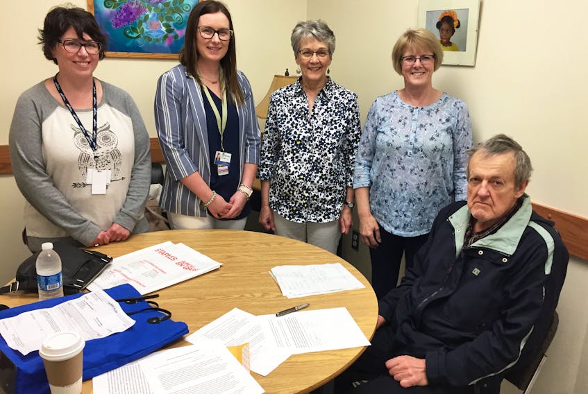 Assisting Lenny with signing up for the Bright Smiles Project: Dental Health for Mental Health, July 3, are student Melissa Fanning (left), social worker Jessie MacDonald, volunteer Gladys MacDougall and project co-ordinator Cecilia McRae from the group Pictou County Mental Illness Family Support Association, who began the project.