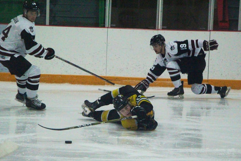 Antigonish Farmers' Mutual Bulldogs centre Fearghus MacDonald tries to maintain control off the puck after being tripped up on this play, versus Strait Pirates Jacob Keagan (left) and Taylor Pierce. The back-and-forth playoff game was eventually won by MacDonald and his Bulldog teammates; 3-2 in overtime. The result sees the series knotted at a game apiece with game three tomorrow evening in Port Hawkesbury.