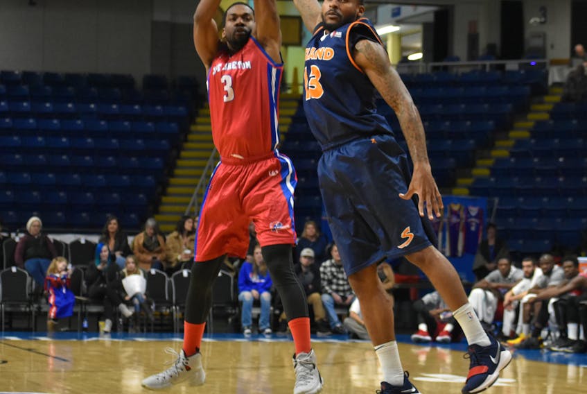 Robbie Robinson of the Island Storm, right, attempts to block a three-point shot by Justin Taylor of the Cape Breton Highlanders during National Basketball League of Canada action at Centre 200 in Sydney on Thursday.