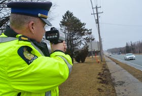 Sgt. Joe Farrell of the Cape Breton Regional Police Service traffic unit points a lidar device at cars travelling on Grand Lake Road. Officers are on the lookout for speeding and aggressive driving offences, which tend to increase as weather gets warmer.
