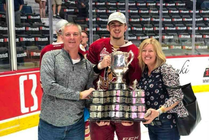 Mitchell Balmas, centre, stands with his parents, Brad and Melanie Balmas, following the championship game of the MasterCard Memorial Cup in Regina, Sask., on May 27. Balmas captured the Memorial Cup title with the Acadie-Bathurst Titan. The 20-year-old forward was traded to Cape Breton on Friday.