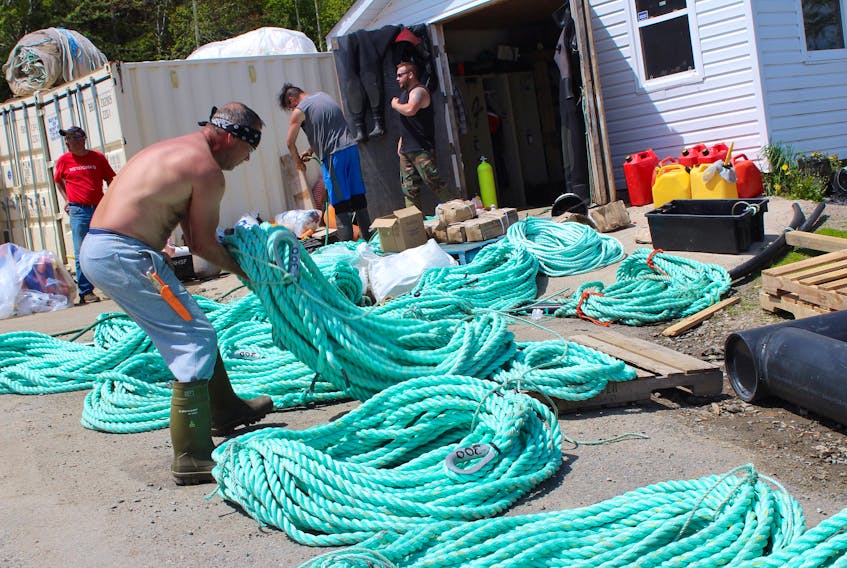 James Martin lines up rope at the Waycobah trout farm on Friday. There were 170,000 steelhead trout harvested last year, while it is expected that another 400,000 trout will this harvested this year.