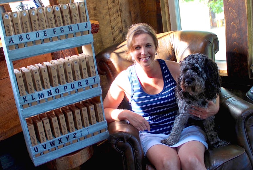 Tonya Blackie sits next to a Bristles with Initials retail display and dog Jimmy at her family’s home in Florence.