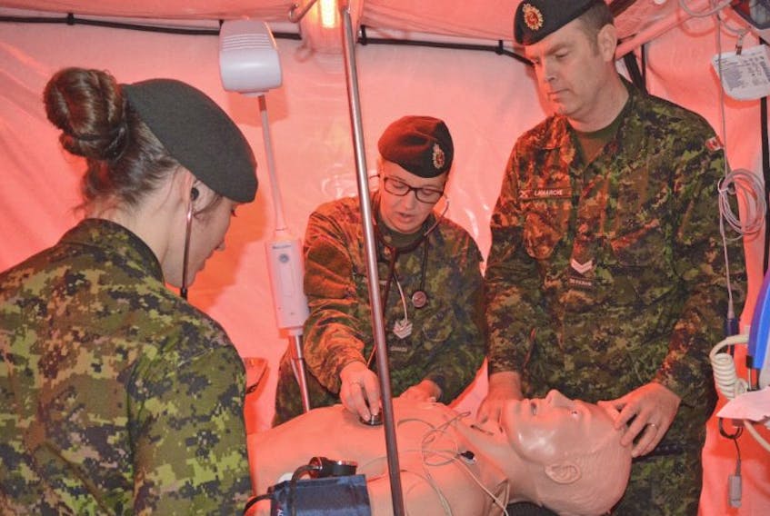 Army reservists, from left, Sgt. Brittany Robinson, Cpl. Candice Ziolkowski and Cpl. Patrick Lamarche used some of their training as medical technicians to check the vital signs of a dummy patient at Saturday’s open house at Victoria Park in Sydney.