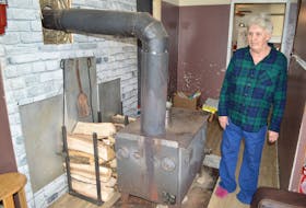Jeanette MacDonald stands by her old wood stove in her home in Glace Bay. MacDonald said after a long wait and initially turned down for a provincial grant to get desperately needed work done to her house she was approved a couple months ago but is having trouble trying to get a contractor to do it and meanwhile is forced to take measures such as duct taping her front door to protect her family from the cold. MacDonald said a couple months have gone by and she's scared she'll lose this grant if she doesn't get help. In the meantime she said the outpouring of generosity from the public — starting with a new roof and continuing with gifts throughout Christmas — will never be forgotten. Sharon Montgomery-Dupe/Cape Breton Post