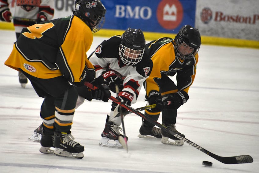 Cody Shaheen-Cole of the Glace Bay Miners, battles for the puck with Northside Vikings teammates Shane Viva, left, and Andrew LeBlanc during Cape Breton Peewee 'A' Hockey League Cape Breton Cup action at the Membertou Sport and Wellness Centre on Friday. Northside won the game 4-2.
