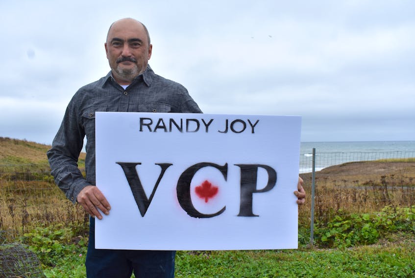 Randy Joy holds one of his election signs in the backyard of his Glace Bay home. A recently retired warrant officer in the Royal Canadian Corps of Signals, Joy founded the Veterans Coalition Party of Canada and is one of seven candidates running for the Sydney-Victoria seat in the Canadian Parliament.