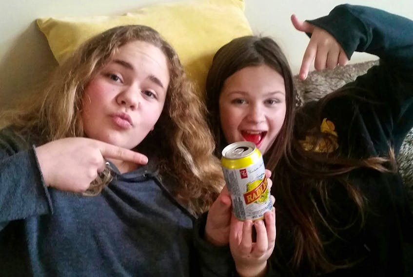 From left, Olivia Gracie and Morgan MacMullin, both 12, were surprised to find cans of de-alcoholized beer with lemonade in their Halloween treat bags. The girls turned the cans over to their moms, who believe the treats were an innocent mistake. Submitted photo/Tanya Gracie