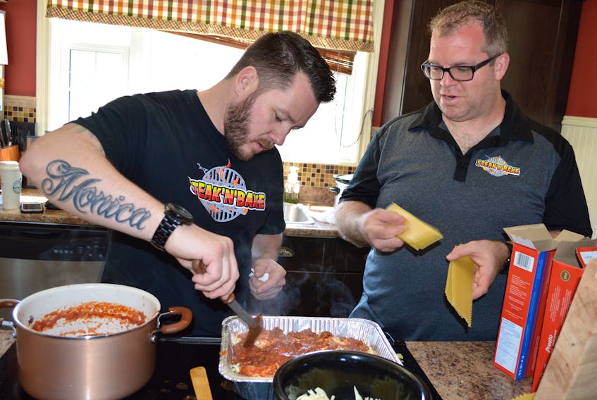Business partners Derick Morrison, left, and Brian Morrison of Glace Bay of the homemade sauce and catering business Steak N’ Bake, prepare lasagnas ordered for an event.