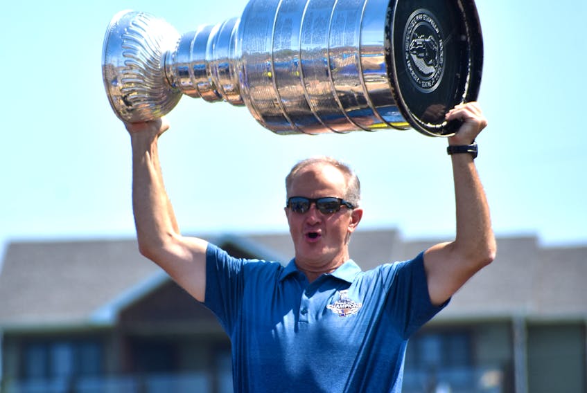 Al MacInnis lifts the Stanley Cup over his head during the Chestico Days parade in Port Hood on Saturday. MacInnis, who won the NHL championship as a senior advisor with the St. Louis Blues in June, and the Stanley Cup were the highlight on the town’s annual festival parade.
