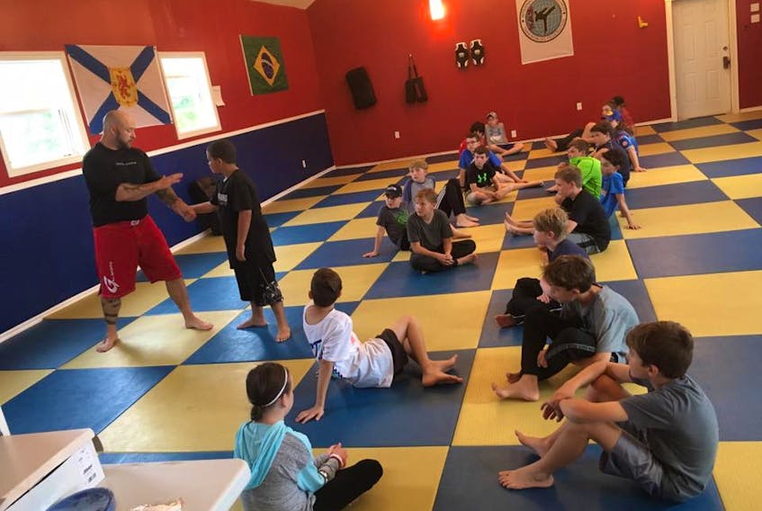 Jimmy Hall, owner of Integrity Martial Arts in Whitney Pier, teaches a group of kids how to get out of a wrist hold during an anti-bullying defence seminar in September.