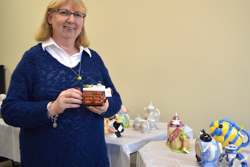 Donna Copper of Whitney Pier holds a teapot her father bought her that she put up for auction to help raise money for St. Mary’s Polish Parish. The auction was held on Sunday and featured 35 pots from Cooper’s private collection of more than 300.