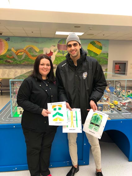 Cape Breton Eagle Kevin Mandolese shows off a few submissions of the colourings of this goalie pads with Tara Baker, a nurse in the pediatrics unit at the Cape Breton Regional Hospital.