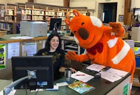 Sydney Credit Union mascot Fat Cat visited librarian Emily Chasse at McConnell Library in Sydney during a recent Super Saturday event.