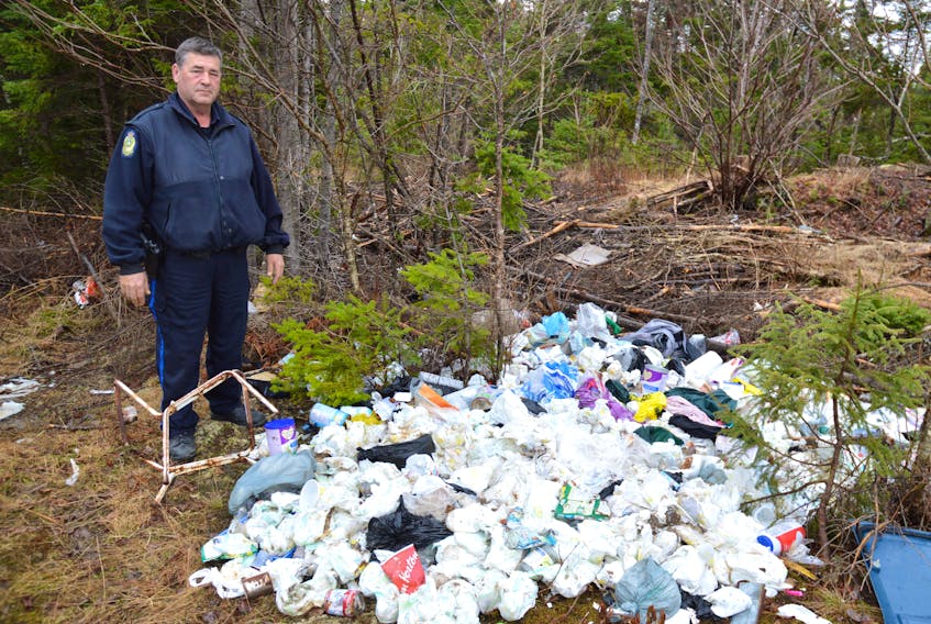 Const. Dan Lewis of the Cape Breton Regional Police Service stands near a pile of dirty diapers on the Morrison Road off the Louisbourg Highway. Lewis, who solely investigates illegal dumping, said he found evidence at the scene on the people possibly responsible and is investigating. Lewis said the number of complaints from the first quarter of last year to the first quarter of this year has doubled — which he believes is good, because it’s an indication people are becoming more aware of illegal dumping and reporting it.