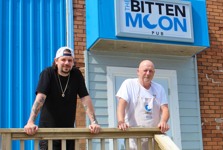Malcolm MacLeod (left) and his father/ business partner Terry MacLeod stand on the patio of their new pub – The Bitten Moon – located at 78 McKeen Street in Glace Bay. The pub, which specializes in craft beer, opened on July 1. The father/son duo own the Sweet Side of the Moon Bakery and Café, located in the front part of the same building as The Bitten Moon Pub, and said the pub was in their long-term business plans when they launched the donut shop three years ago.