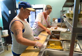 Florence MacNeil of New Victoria, left, a volunteer at Loaves and Fishes, and Marguerite MacDonald of Sydney, culinary supervisory, prepare takeout meals on Tuesday at the Sydney facility. Manager Marco Amiti said despite the COVID-19 pandemic, Loaves and Fishes has managed to stay open and is serving on average 100 individuals a day, about half the number of meals served before the pandemic.