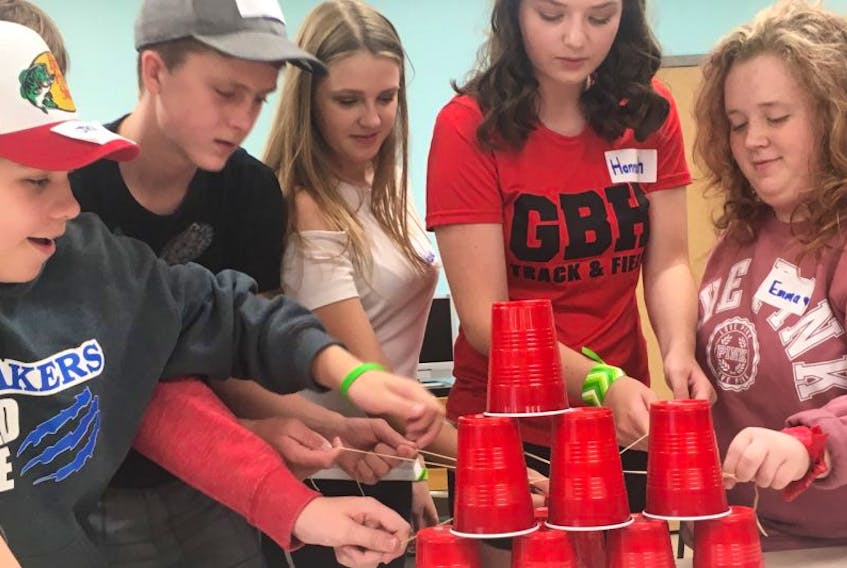 Hannah Livingston (fourth from the left), a member of the Glace Bay High School Headstrong group, works on a cup challenge with some former Oceanview Education Centre Grade 9 students entering Grade 10 Thursday (from the left) Jack Barry, Colton Deering, Nicole MacDonald and Emma Barrett. The challenge was part of an Amazing Race Glace Bay High Edition event to provide a fun way to introduce the students to the high school.