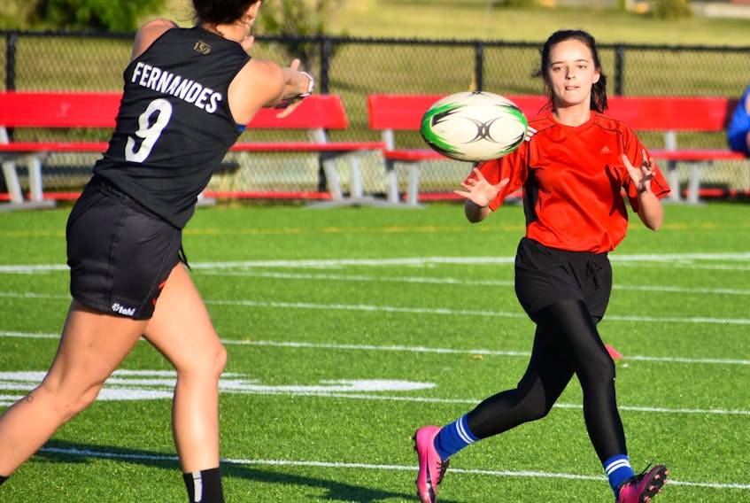 Jayden Detcheverry, right, receives a pass from teammate Brittni Fernandes during a recent women’s rugby practice at Open Hearth Park in Sydney. The team is looking for more players with the goal of fielding a women’s ‘B’ division team in the Rugby Nova Scotia league next summer.