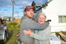 Jeremy Locke, owner of Locke's Roofing and Construction in Bridgeport, shares an emotional moment with Jeanette MacDonald of Minto Street, Glace Bay, while working on Monday to construct a new roof for her free of charge with the help of relatives and volunteers Locke simply wanted to help her out after noticing her roof was in deplorable condition. Locke said after the story broke in the Cape Breton Post on Nov. 1, he was shocked by the reaction, with many other Cape Breton businesses jumping in to help in some way.