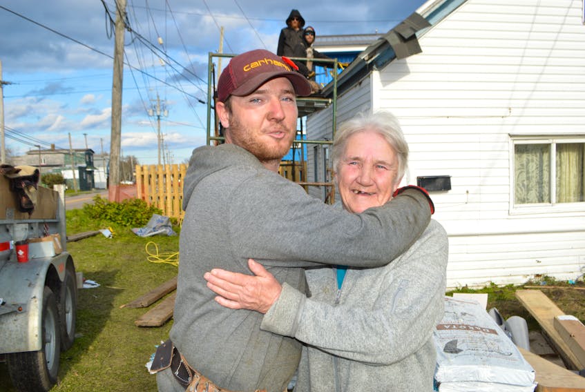 Jeremy Locke, owner of Locke's Roofing and Construction in Bridgeport, shares an emotional moment with Jeanette MacDonald of Minto Street, Glace Bay, while working on Monday to construct a new roof for her free of charge with the help of relatives and volunteers Locke simply wanted to help her out after noticing her roof was in deplorable condition. Locke said after the story broke in the Cape Breton Post on Nov. 1, he was shocked by the reaction, with many other Cape Breton businesses jumping in to help in some way.