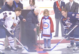 Mary Christina (Chris) MacIntyre, middle, drops the ceremonial puck during the opening of the 2006 Esso Cup women's national hockey tournament at Centre 200 in Sydney. T.J. COLELLO • CAPE BRETON POST.