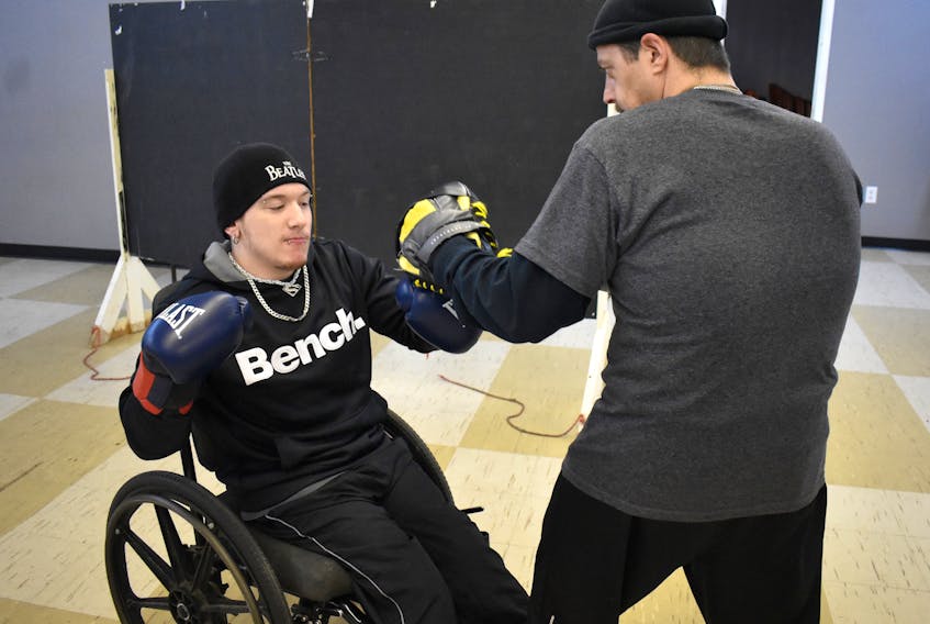 Brandon Leslie, left, works the pads with coach Dan Pottie during a recent training session at Ring 73 in Glace Bay. The 26-year-old wheelchair boxer will participate in the club’s boxing card on Dec. 7, fighting Aaron Kinch of Dartmouth.