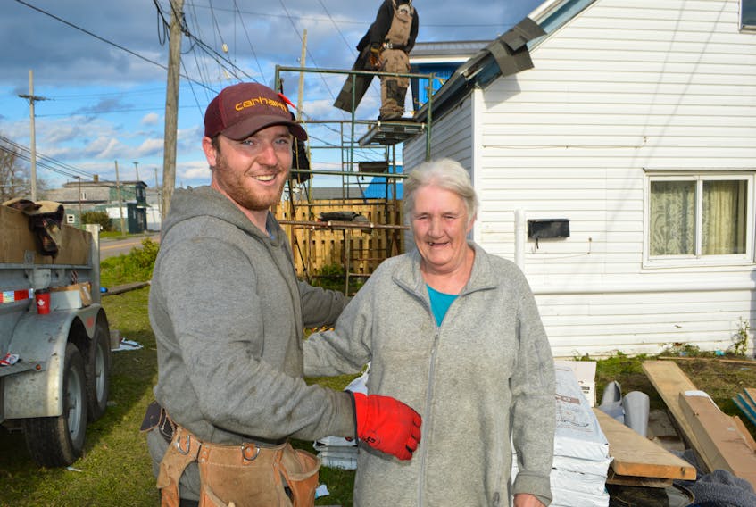 Jeremy Locke, owner of Locke's Roofing and Construction in Bridgeport, spends a few moments with Jeanette MacDonald of Glace Bay, while building her a new roof at his own expense, tired of seeing her and her grandchildren living with an old leaky roof. MacDonald said she's so grateful to Locke and other companies who have since stepped up to help in some way due to Locke's kind gesture.