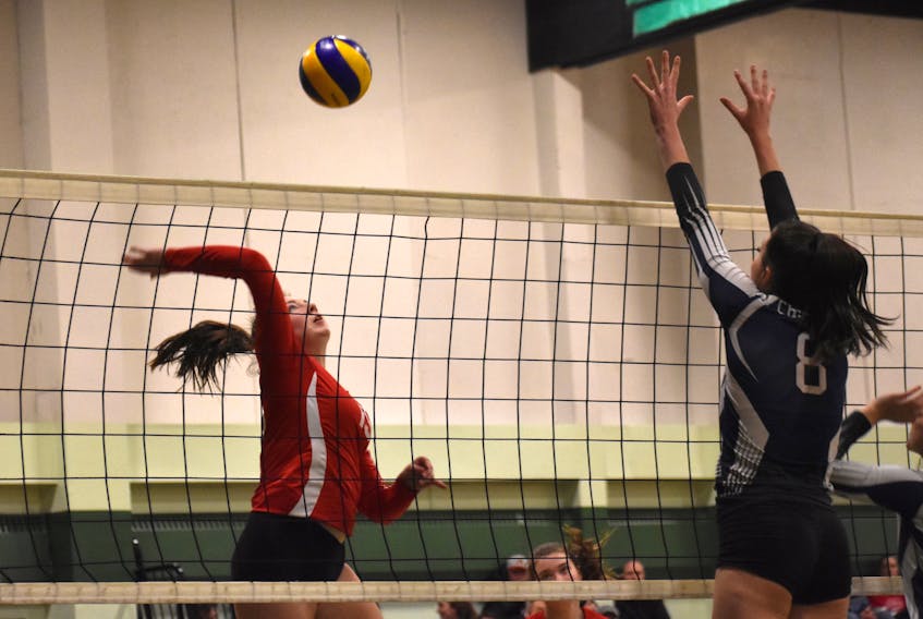 Emily Phillipo of Riverview Ravens, left, hits the ball as Talia Vydykhan of the Charles P. Allen Cheetahs defends during Nova Scotia School Athletic Federation Division 1 girls’ volleyball provincials last December at Memorial High School in Sydney Mines. The province has announced school gyms will reopen to sports and community activity.