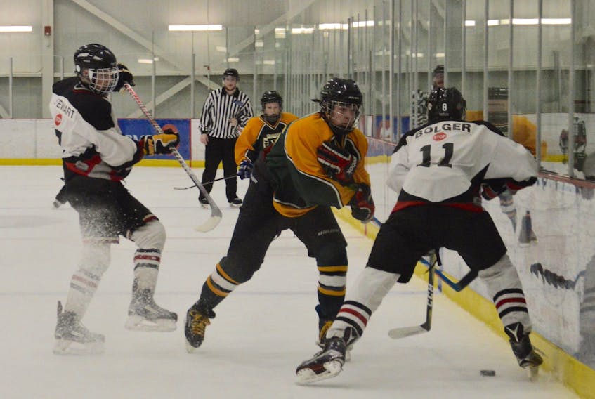 Ian Jenkins, middle, of the Northside Vikings prepares to land a check on Jakob Bolger, right, of the Truro Bearcats during a game at the Royal Canadian Legion Bantam ‘AA’ Tournament at the Membertou Sport and Wellness Centre in January. Minor hockey registration numbers vary across Cape Breton Island, depending on associations.
