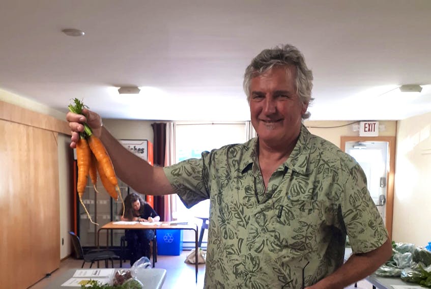 Peter Finch, an organic farmer from outside of Toronto who moved to Cape Breton, is shown holding carrots. Finch volunteers with the Cape Breton Food Hub. The food hub recently launched the 50 per cent local celebration, which encourages residents to purchase 50 per cent of their food from local producers.