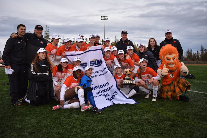 The Cape Breton Capers women’s soccer team is pictured with the Atlantic University Sport championship banner and trophy following its 3-2 win over the Acadia Axewomen in the AUS championship on Sunday in Sydney. The Capers will open the 2019 U Sports women's championship today against the Toronto Varsity Blues.