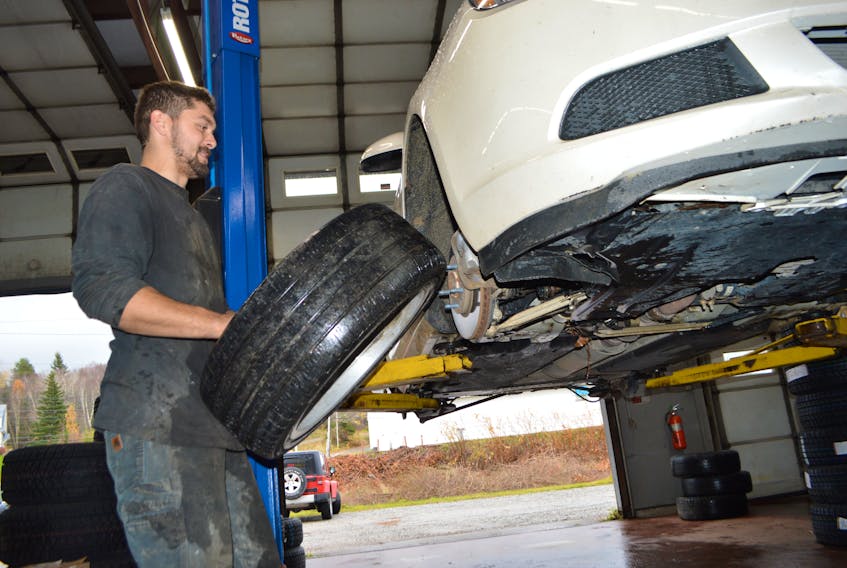 Connor Gibbons, a technician at Ok Tire in Sydney River, works at putting snow tires on a vehicle, Wednesday. Chess Miles, service manager, said as soon as the word snow is part of a forecast this time of year, there is a mad scramble for people to get their snow tires on.