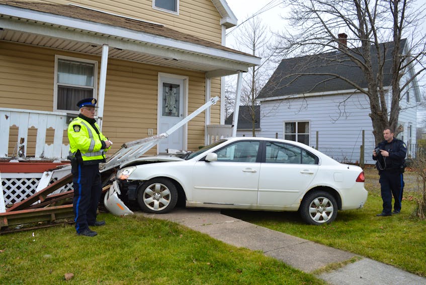 Const. Calvin Thomas, left, and Const. Dave Kelly of the Cape Breton Regional Police Service investigate the scene of a single-vehicle accident Wednesday, after a car crashed into the front of a two-unit house at the corner of Union Street and Park Street in Glace Bay. Police say the accident was the result of a new driver simply making a driving error. Sharon Montgomery-Dupe/Cape Breton Post