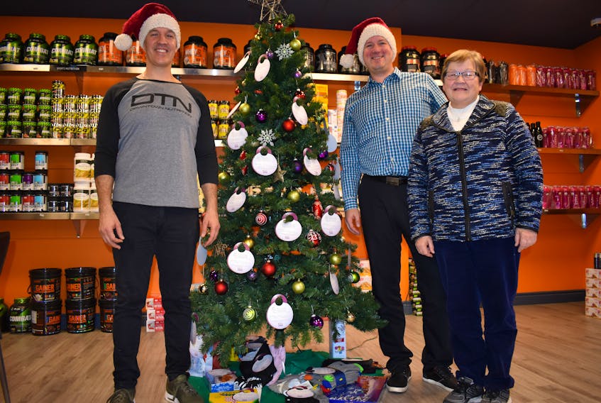 From left, Wayne Miller, owner of Downtown Nutrition in Sydney River, stands with Chris Robertson, owner of Home Instead Senior Care in Sydney, and Jane Currie, a retired nurse. Home Instead partnered with Downtown Nutrition to help isolated seniors by taking gift donations from the public to help them cope with the holiday season. CHRISTIAN ROACH/ CAPE BRETON POST