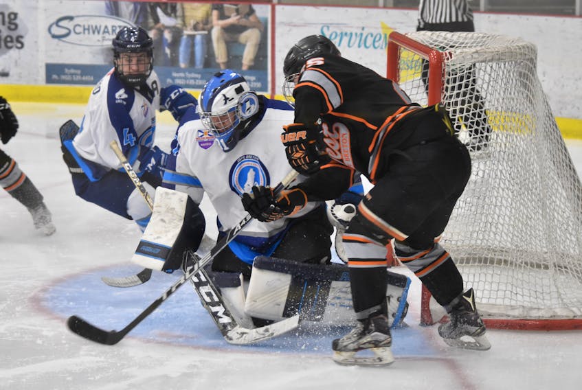 Stephen Fox of the Cape Breton West Islanders, right, looks to scoop home a rebound on Cape Breton Unionized Tradesmen goaltender Seth Crowe while Dylan MacLeod of the Tradesmen looks on during Nova Scotia Eastlink Major Midget Hockey League play Wednesday at the Membertou Sport and Wellness Centre. Fox fired a hat trick, including the winner in the third, in a 5-4 Islanders win. T.J. Colello/Cape Breton Post