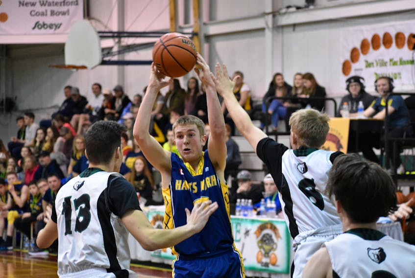 Breton Education Centre Bears players Jordan Hennessy, left, and Tony Tighe, right, surround Griffin Smith of the Hants North Flames during the third day of action at the annual New Waterford Coal Bowl Classic high school basketball tournament at BEC gym, Wednesday. Smith led the Flames to a 67-58 win.