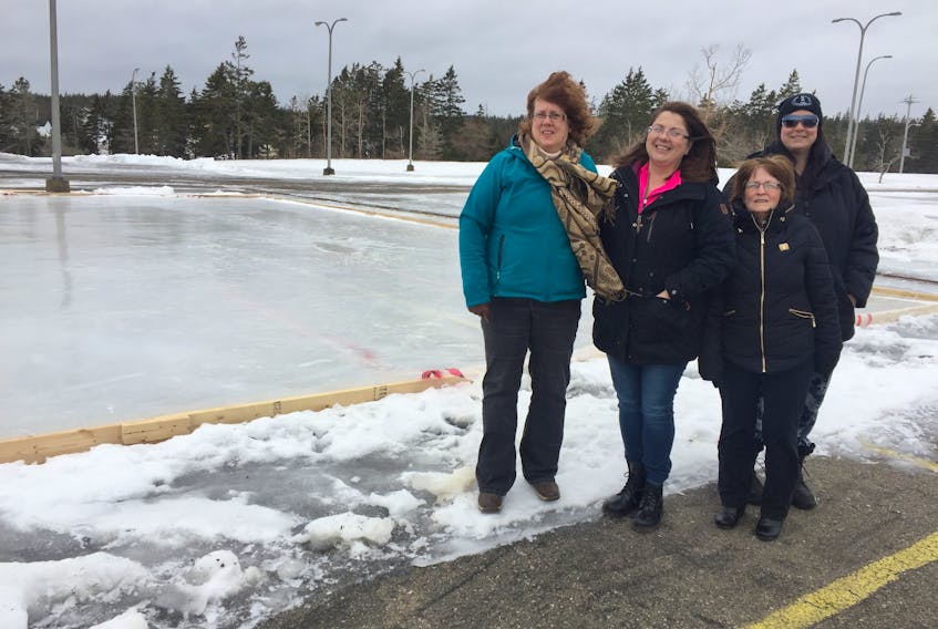 From left, Colleen Wheeliker, Rose Steylen, Louise Carter and Alison Bussey are some of the core members of the newly created Louisbourg and Area Partnership for Programs (LAPPS) community group. They are standing beside a community rink they have set up in the parking lot of Louisbourg Seafoods fish processing plant.
