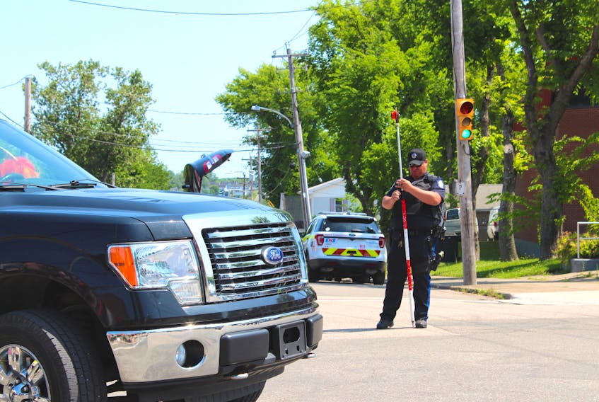A Cape Breton Regional Police officer conducts a preliminary investigation from the scene of an accident involving a 10-year-old boy who was struck by a parade float during the 19th annual Cape Breton Pride Parade. The boy was not seriously injured.