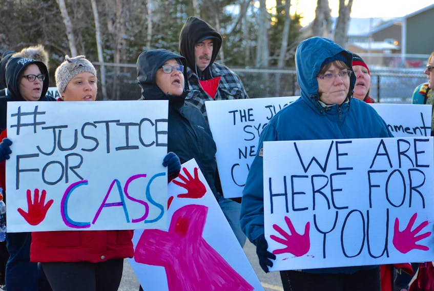 Erin Moore, left, and Nancy Clements hold signs as they walk through the streets of Membertou during the Justice for Cassidy Bernard and missing and murdered Indigenous women and children walk on Friday. Close to 80 people attended the walk.