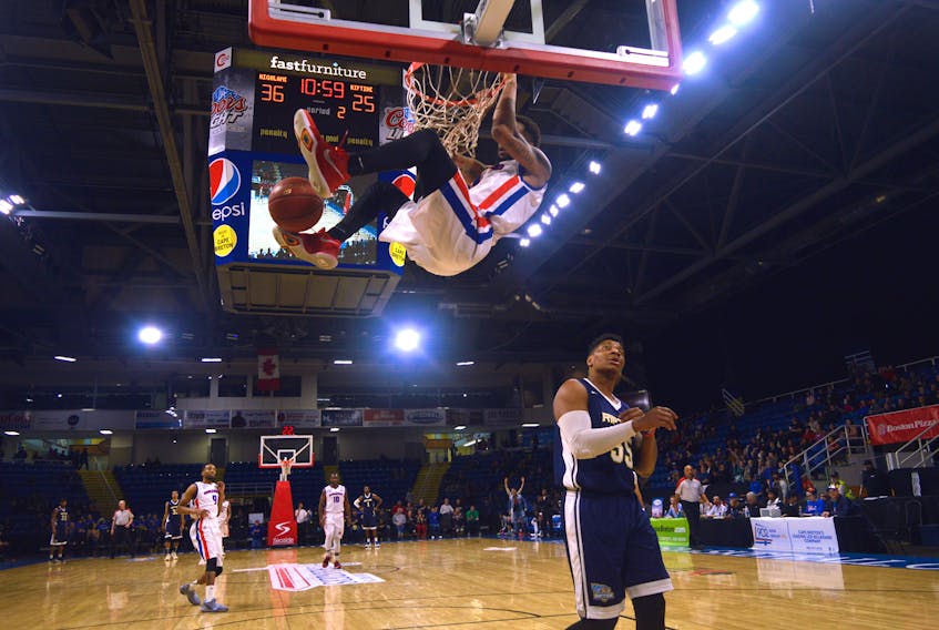 Duke Mondy of the Cape Breton Highlanders dunks the ball as Darin Mency of the Saint John Riptide looks on during National Basketball League of Canada action at Centre 200 on Thursday evening. The Highlanders won the matchup, 113-100.