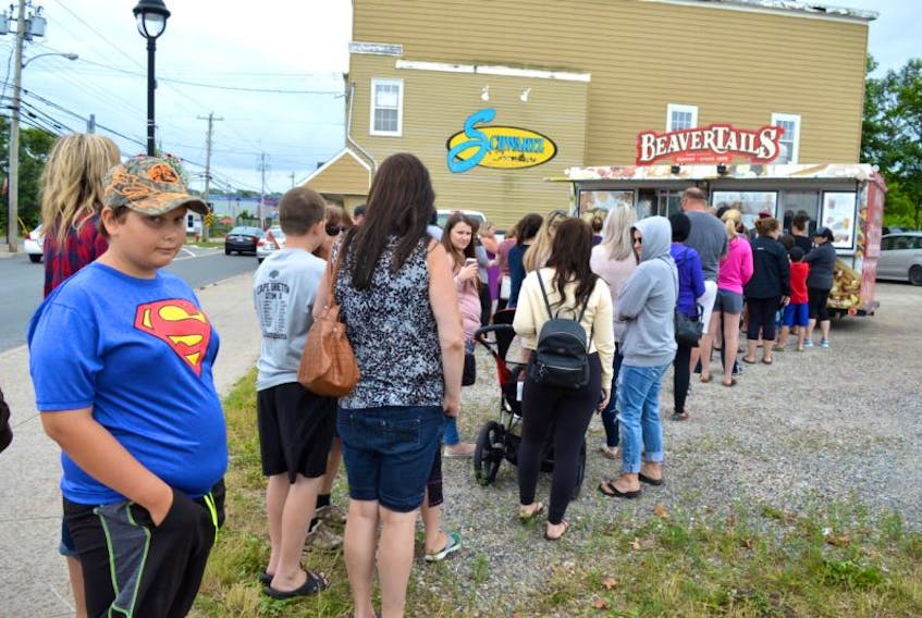 Colton Campbell, 10, of Glace Bay waits patiently at the BeaverTails mobile set up on Commercial Street in Glace Bay on Tuesday where a long line remained steady throughout the day after word got out it was there. Campbell said he had tried BeaverTails pastry before in Moncton and couldn’t wait to get another one.