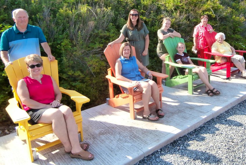 Family members sit for a photo in the chairs dedicated to their loved ones. Left to right, David Wadden’s wife Darlene Wadden with David’s father Kenzie; Donald Giovannetti’s wife Heather seated, with their daughter Allison; Charles and Lillian Giovannetti’s great-granddaughters Lilly and Charlotte Gouthro; Joe Peach’s wife Joyce, seated, and daughter Norma.