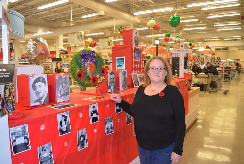 Laurie Hatcher, an employee at Atlantic Superstore, stands in front of a Remembrance Day display she created at the Northside grocery store.