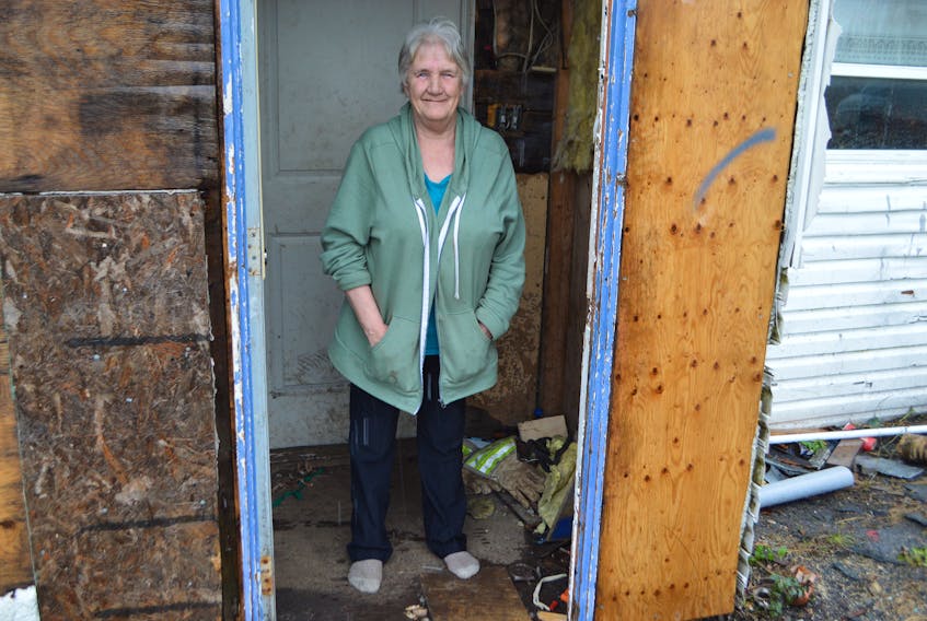 Jeanette MacDonald of Glace Bay stands at the doorway of her home last week and for the first time in years she was not bothered by the rain. Good Samaritan Jeremy Locke recently put a new roof of the home and it no longer leaks.