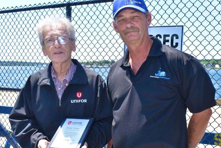 Between the two of them, they have more than 100 years working as stevedores. Bobby Yhard, left, accepts a plaque for more than 60 years of work as a longshoreman from UNIFOR president Robert Parsons, who has worked in the same job for 40 years.