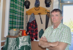 Steve Drake of New Waterford looks over a corner in his garage where he has a memorial to his coal miner father, the late Steve Drake Sr., that includes his father’s favourite lumberjack shirt, work cap, hard hat and some tools, together with some of his own former coal mining equipment.